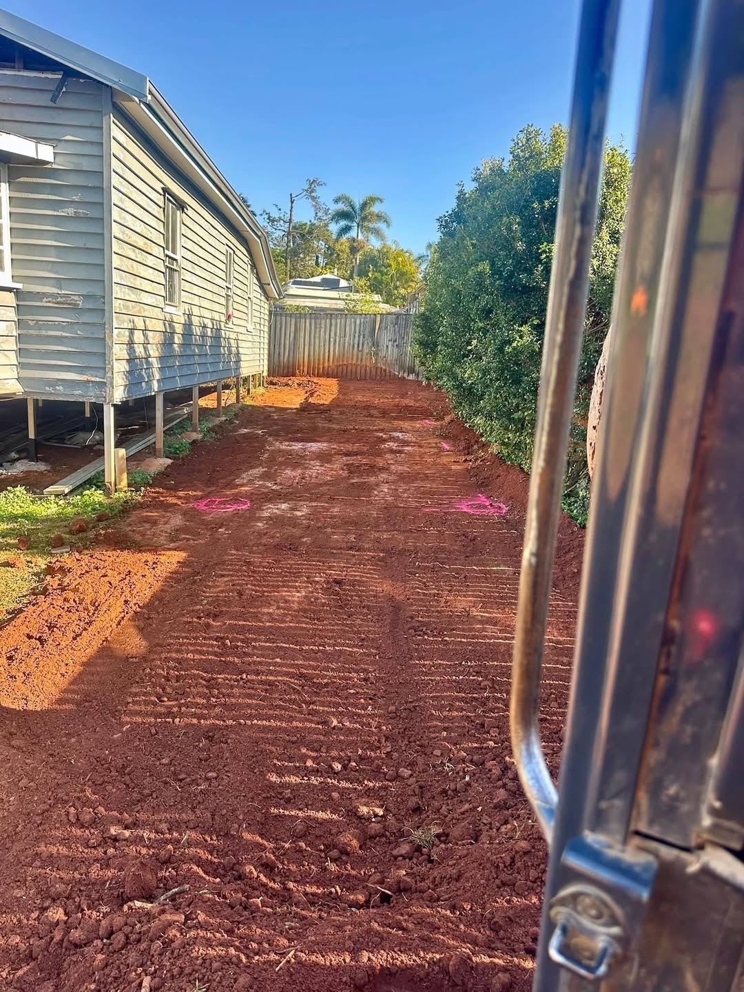 Prepared residential ground beside a Queenslander home